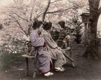 Three Young Japanese Girls Sitting on a Bench