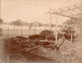 An arbor, lake and town. Man near water.