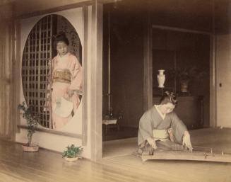 Two women, one playing koto