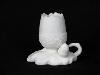 [Acorn-shaped parian vase with handle with small acorn ornament on leaf-shaped base]