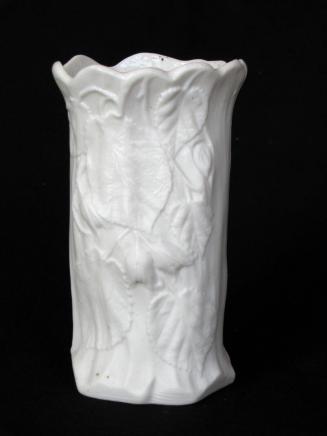 [Cylindrical parian vase with interior glaze and scalloped flared lip and low relief floral and leaf design on body]