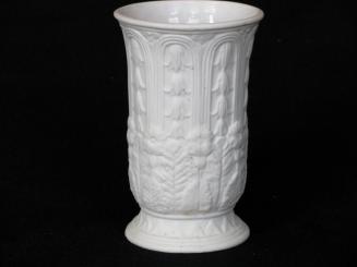 [Cylindrical parian vase with glazed interior, and low relief floral and leaf motif and splayed base]
