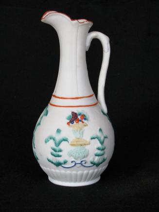 [Pear shaped parian ewer with low relief applied glaze fruit basket and leaf patterns background mottling and fluted base]