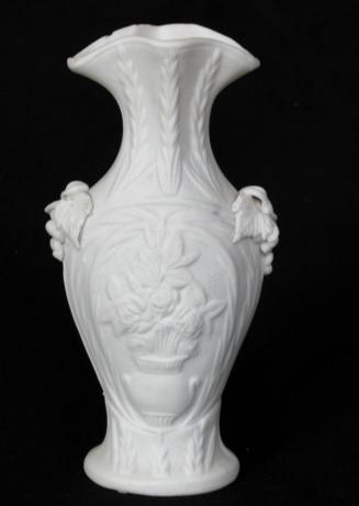 [Amphora-shaped parian vase with flared lip, high relief wheat on neck, applied grape clusters on shoulders and high relief floral motif on body]
