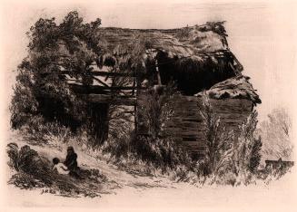 [Rundown barn with two figures seated in grass]