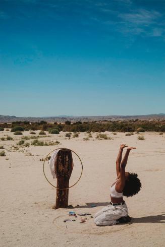 [Woman kneeling in a desert landscape]