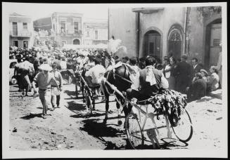 Scene with villagers walking and riding in horse-drawn carriages