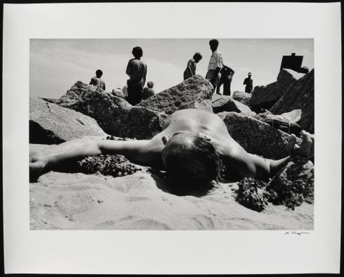 Man lying on the beach between rocks, New York