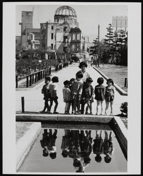 Japan: Group of visitors inside the Hiroshima Peace Memorial Park. In the background, the Genbaku Dome, Hiroshima