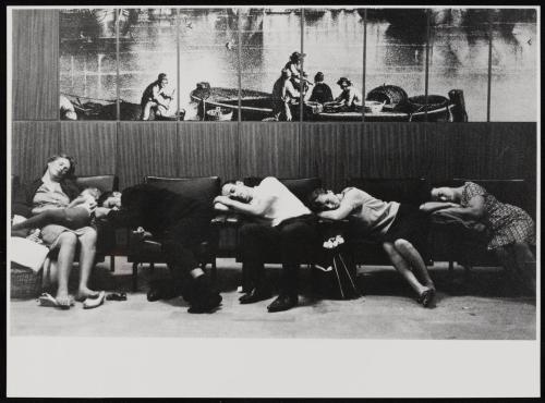 People sleeping in waiting room under boat mural