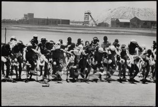 Group of tribesmen dancing in front of mine, South Africa