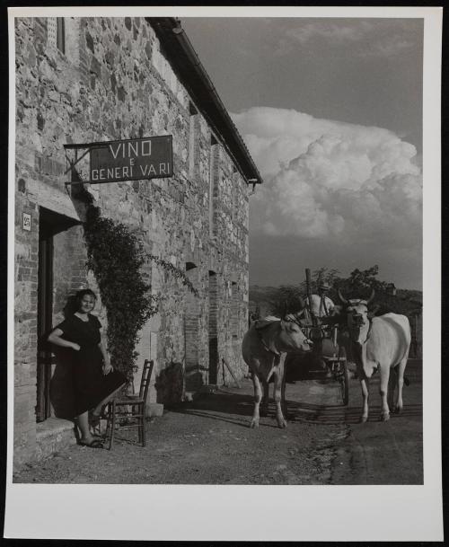 Woman standing in front of wine shop, Italy