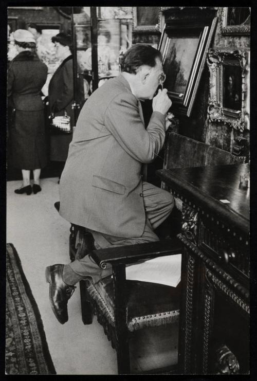 Man examining painting at art and antique auction, Amsterdam, Holland