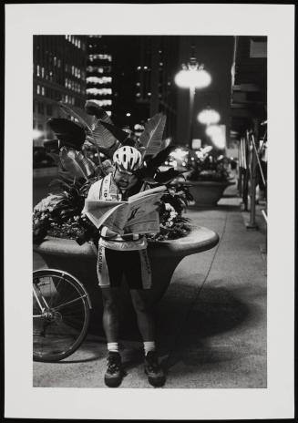 Chicago (man in biking attire reading newspaper at night