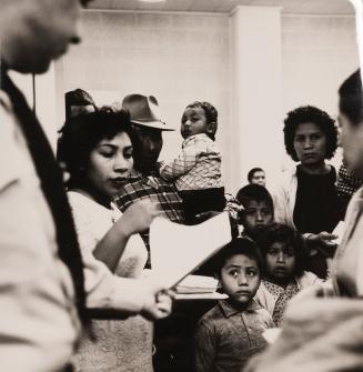 Immigration from Mexico to the USA: all people who come from Mexico and do not yet have a health pass must first of all go to the sanitary control waiting room. Hundreds of people are waiting there every day - on some days their number is in the thousands - for medical check-ups. Those who come to USA for a short visit as tourists are quickly cleared, while seasonal workers and immigrants, on the other hand, often have to spend a whole day here and subject themselves to strict tests. Children's health is also strictly examined. Off camera two men, who are experts from the Ministry of Health of Cambodia, are studying the methods of quarantine in El Paso, Texas