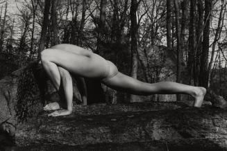 Kate, nude, does yoga pose on a rock in forest, USA