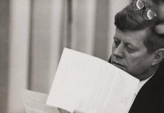 President John F. Kennedy reading memos