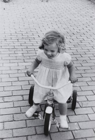 Caroline Kennedy riding a tricycle