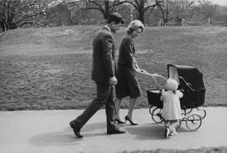 Ted and Joan Kennedy pushing pram with daughter, Kara, Boston