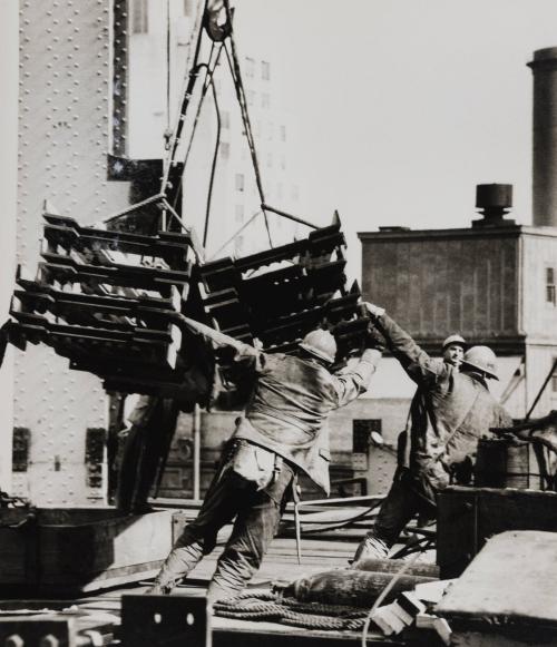 Construction workers facilitating the landing of construction material