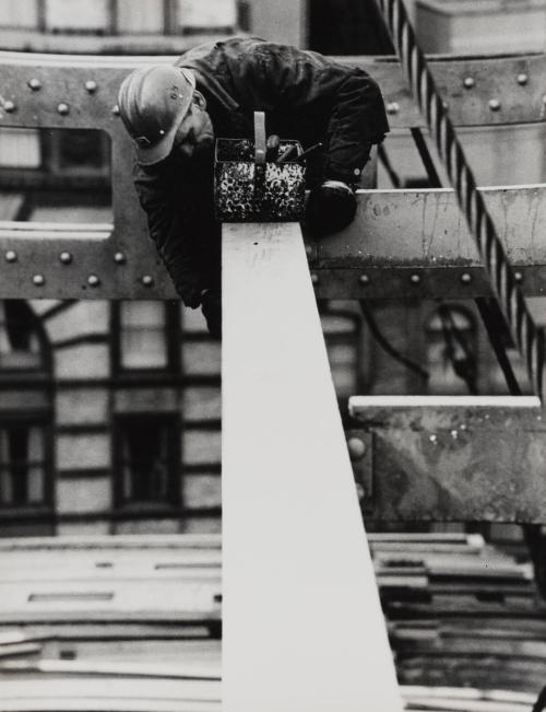 Construction worker fixing beam with tool box