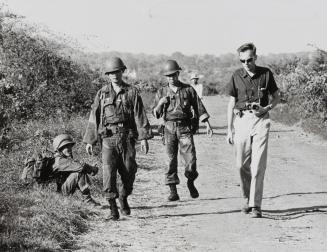 Associated Press correspondent Malcolm Browne, right, in the field with Vietnamese troops, searching for two downed American fliers, September 1965