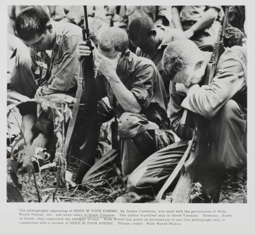 A crowd of soldiers kneeling, holding their armaments and bowing their heads. 