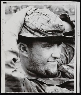 A GI smiles as he waits for helicopter lift to pull his unit out of Fire Support Base Speer, six miles inside the Cambodian border, northeast of the Fishhook, 1970