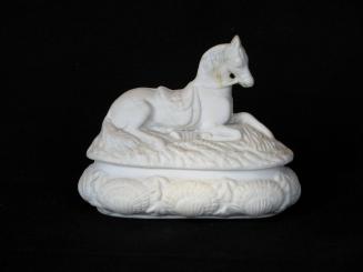 [Lidded parian box with reclining horse on lid and high relief seashell decoration on sides]
