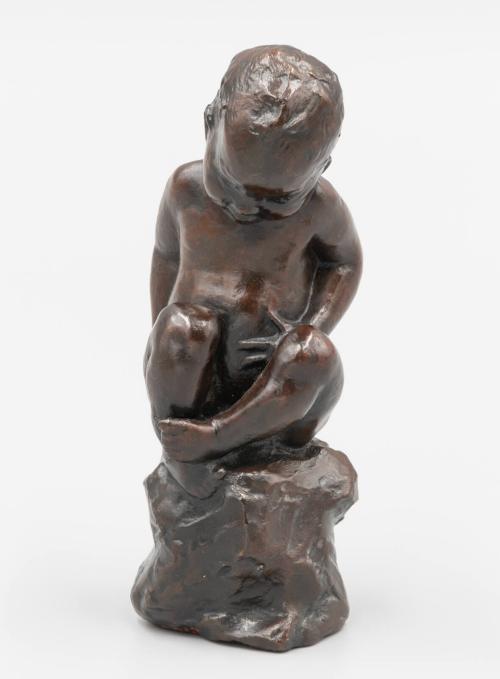 Child seated on a rock