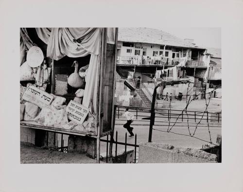 Street scene with boy running towards window display in Mea Shearim, the Hassidic Jewish quarter of the city of Jerusalem, 1968