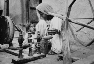 Mother at loom with child, Pakistan, ca. 1960