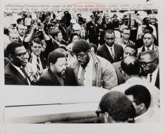 The casket of Dr. Martin Luther King is slowly lowered to the ground by aides of the famed civil rights leader on arrival at the funeral home here, Atlanta, April 5, 1968