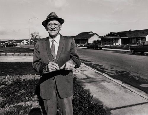 [Man wearing suit, tie, hat, and glasses]