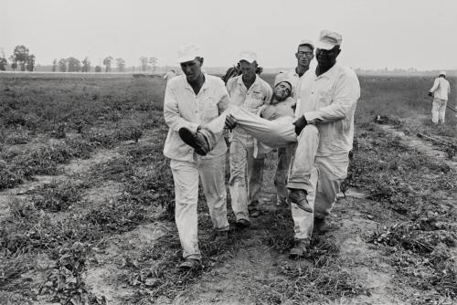 Heat exhaustion (man being carried by prisoners)