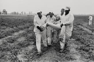 Heat exhaustion (man being carried by prisoners)