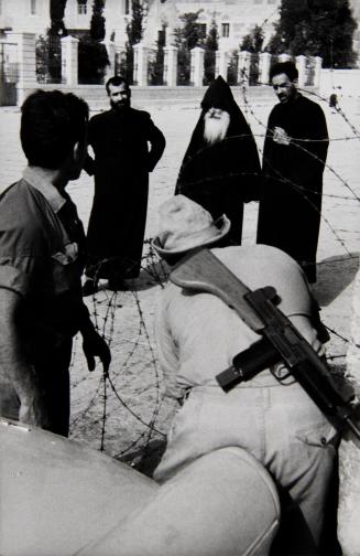 Shortly after Six Day War, before the church of Nativity, Greek Orthodox priests watch Israeli Soldiers set up barbed wire, Bethlehem, Israel