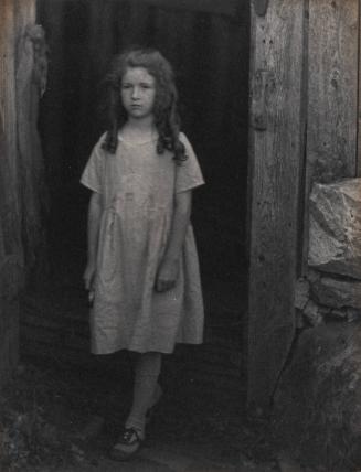 [Portrait of girl standing in doorway]