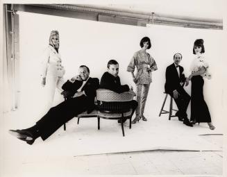 [Bill Blass, John Weitz, and John Moore seated with models standing by]