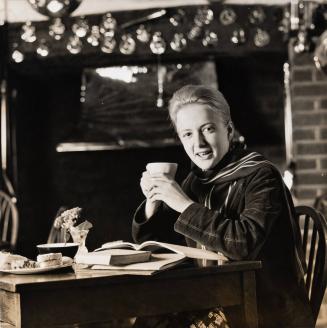 [Advertisement with girl drinking at café with book and pastries]