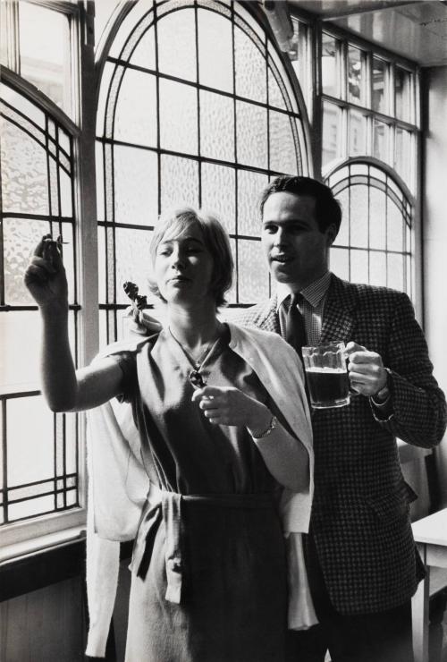 [Couple playing darts while having a beer]