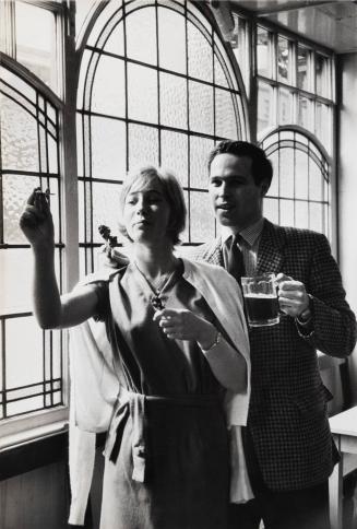 [Couple playing darts while having a beer]