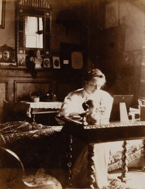 [Woman sitting at desk]