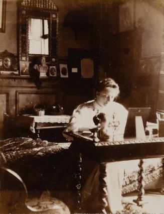 [Woman sitting at desk]