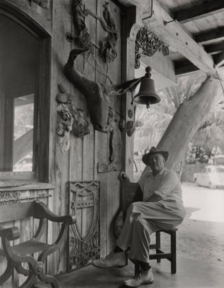 Untitled (Waldo Sexton seated in chair on porch  at the Driftwood Inn, Vero Beach, Florida)